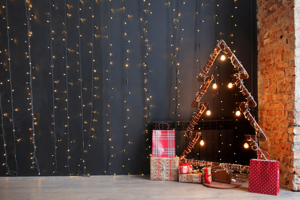 Fotografía árbol de navidad en la pared hecho con luces navideñas, tendencias de decoración navideña